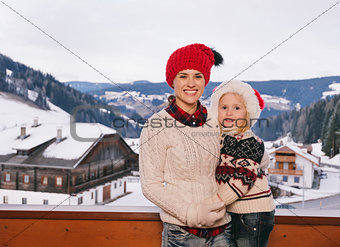 Mother and child standing on balcony overlooking mountains