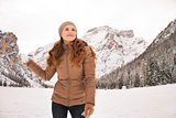 Happy woman with snowball outdoors among snow-capped mountains