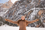 Happy woman outdoors among snow-capped mountains rejoicing