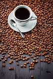 Cup with fragrant coffee drink on beans background