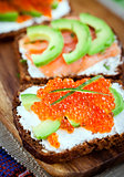 Appetizer with red caviar, avocado, salmon and creamcheese