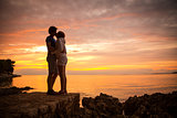 Couple Embracing and Kissing at Sea Sunset