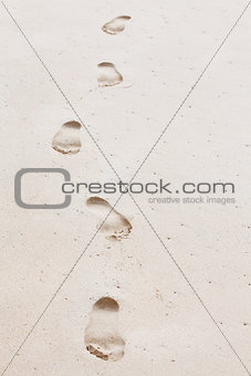 Human footprints leading towards the viewer. Copyspace on right