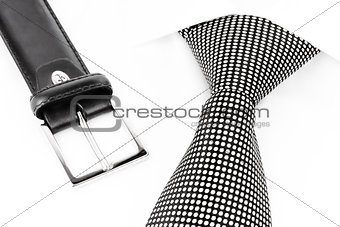 black and white spotted tie knotted Windsor and leather belt
