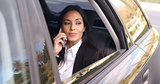 Beautiful business woman on phone in automobile