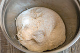 Homemade bread dough in a metal bowl.