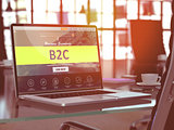 B2C on Laptop in Modern Workplace Background.