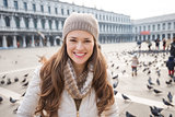 Portrait of smiling woman on Piazza San Marco among pigeons
