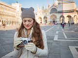 Young woman with retro photo camera standing on Piazza San Marco