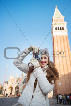 Woman taking photos with camera near Campanile di San Marco