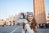 Woman taking photos with retro photo camera on Piazza San Marco