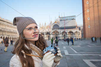 Young woman tourist with retro photo camera on Piazza San Marco