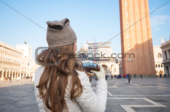 Seen from behind woman with retro camera on Piazza San Marco