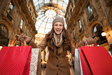 Woman in Galleria Vittorio Emanuele II showing shopping bags