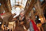 Happy woman with shopping bags in Galleria Vittorio Emanuele II