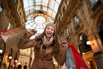 Happy woman with shopping bags in Galleria Vittorio Emanuele II