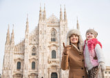Mother showing something to daughter while standing near Duomo