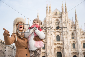 Smiling mother showing something to daughter near Duomo, Milan