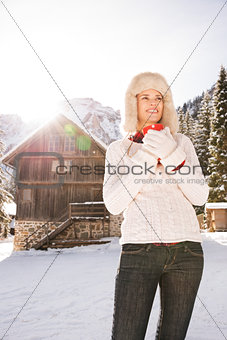Woman looking into distance while standing near mountain house