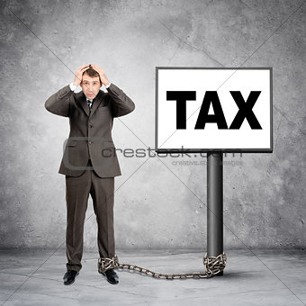 Businessman word tax on post sign