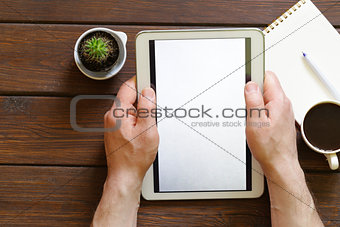cup of coffee, notepad and an electronic tablet on a wooden background, top view