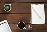 cup of coffee, notepad and an electronic tablet on a wooden background, top view