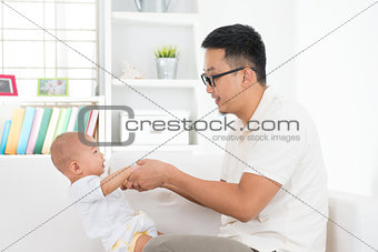 Asian father playing with baby 