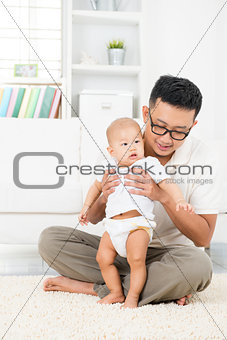 Asian father and baby playing at home. 