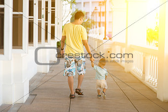 Father and child walking holding hands