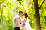 Beautiful wedding couple in park. They kiss and hug each other