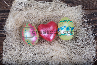 Easter eggs with  red heart symbol in natural nest