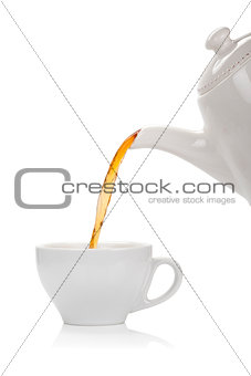 Pouring tea into a cup isolated on white