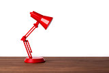 Red metal lamp on a wood desk