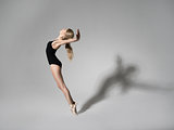 Ballerina in black outfit posing on toes