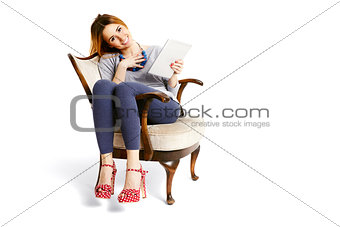 Woman sitting on an armchair with tablet