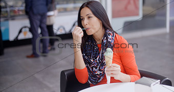 Woman eating an ice cream in a parlor or cafe