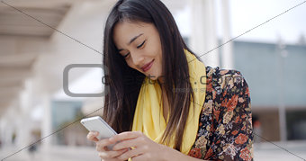 Chic young woman checking her text messages