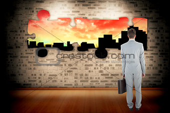 Composite image of businessman holding his briefcase