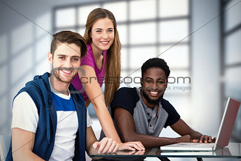 Composite image of creative team using laptop