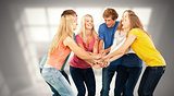 Composite image of group of friends about to cheer with their hands stacked