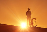 Composite image of silhouette beside euro symbol