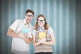 Composite image of geeky hipster couple holding books and smiling at camera