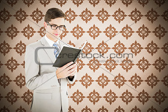 Composite image of geeky businessman reading black book