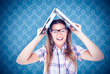 Composite image of geeky hipster holding her laptop over her head
