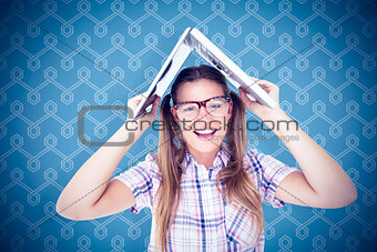 Composite image of geeky hipster holding her laptop over her head