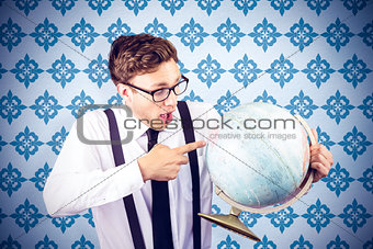 Composite image of geeky businessman pointing to globe