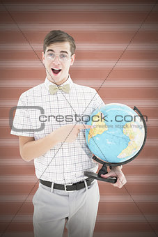 Composite image of geeky hipster holding a globe smiling at camera