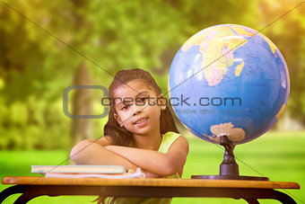 Composite image of cute pupils sitting at desk