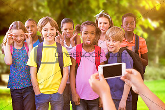 Composite image of cute pupils using mobile phone