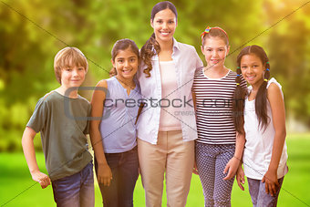 Composite image of cute pupils and teacher smiling at camera in computer class